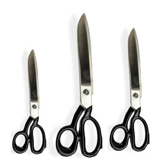 "Heavy duty scissors cutting fabric on worktable"